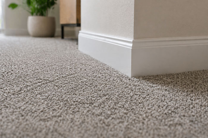 Detail van tapijt met strakke afwerking en plinten Tilburg